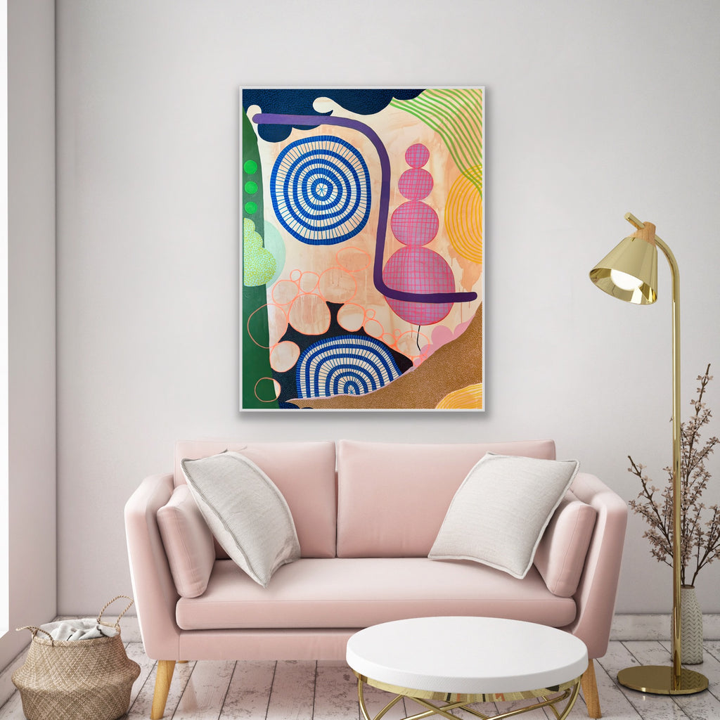 Colorful abstract painting above a pink sofa in a living room.
