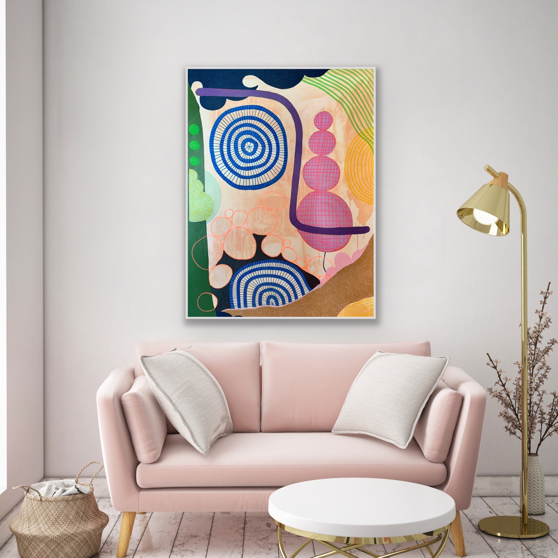Colorful abstract painting above a pink sofa in a living room.