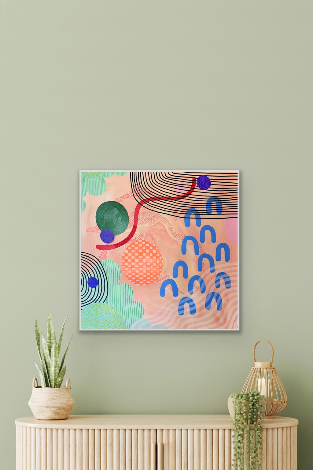 Abstract art print on a wall above a wooden console table with decorative items.