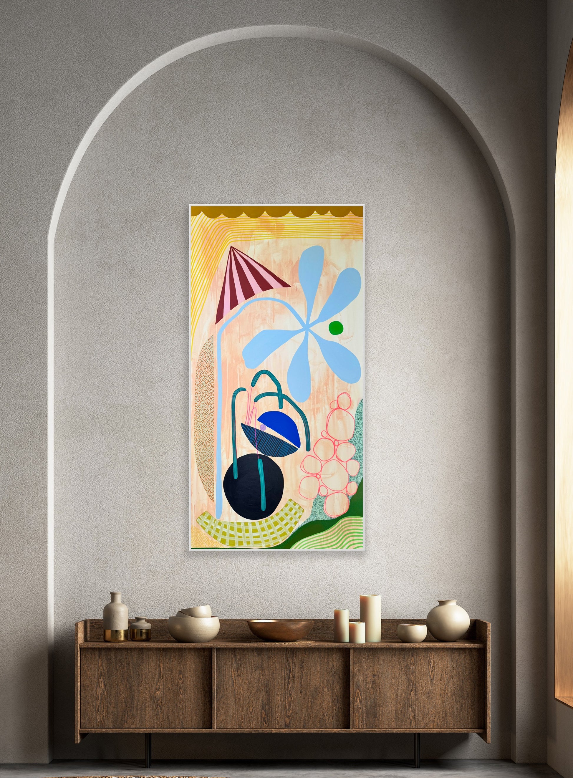 Abstract artwork on a wall above a wooden console table with decorative items.